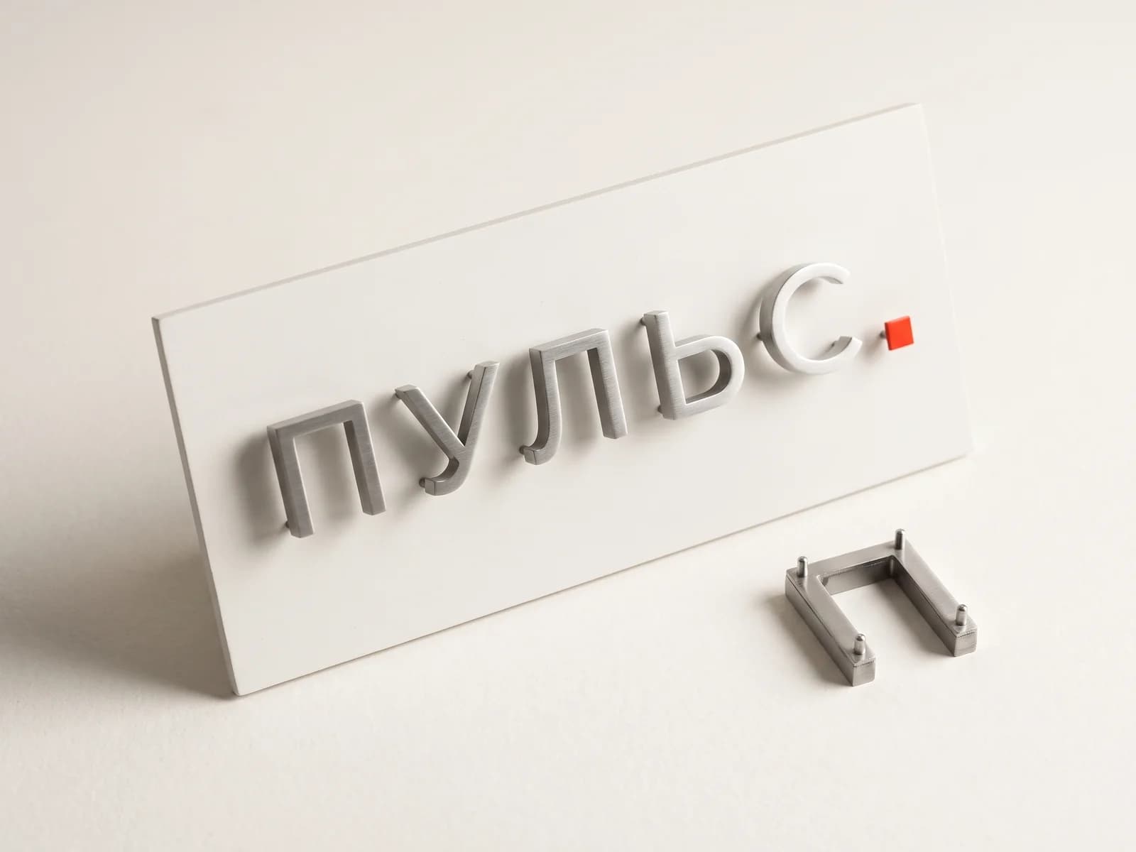Металлические буквы «ПУЛЬС» на белой панели, рядом отдельная буква